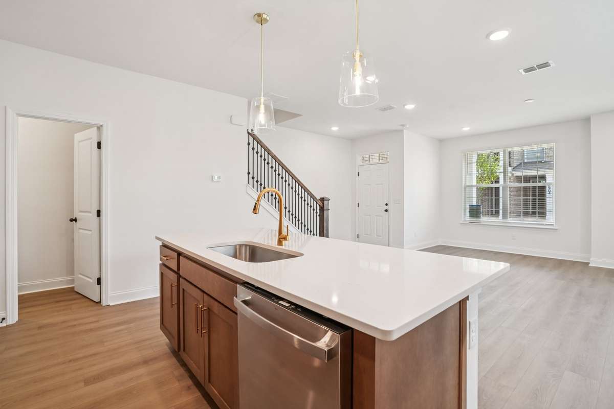 Gold hardware, pendant lighting, and sleek appliances beautifully accentuate the modern kitchen, adding warmth, style, and a polished, designer-inspired finish.
