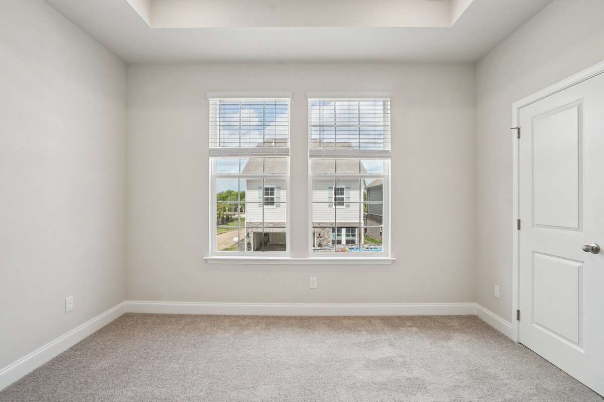 The Primary Bedroom features a tray ceiling that adds a sense of height and elegance, making the space feel open and inviting.
