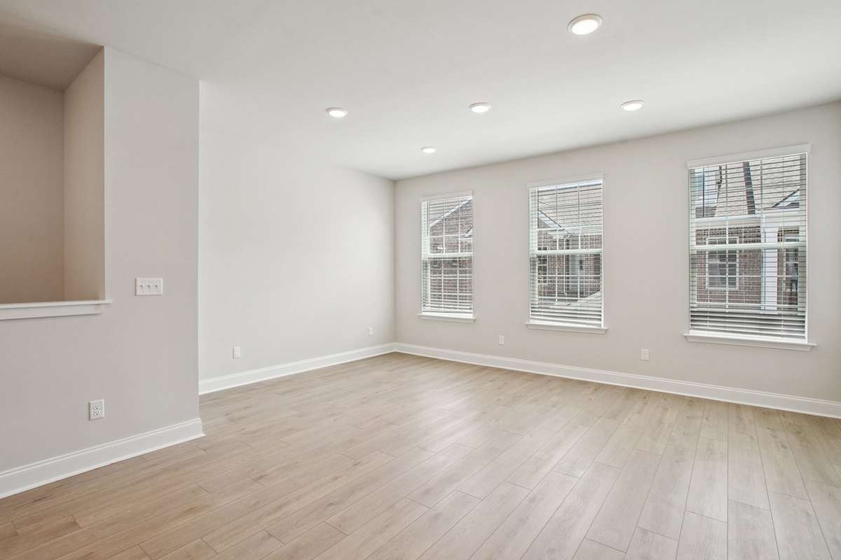 The Great Room features three large windows that flood the space with natural light, creating a bright and inviting atmoshpere.