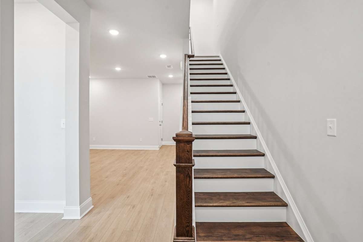 Hardwood stairs connect the first and second floors, blending durability and functionality with timeless style and natural beauty.