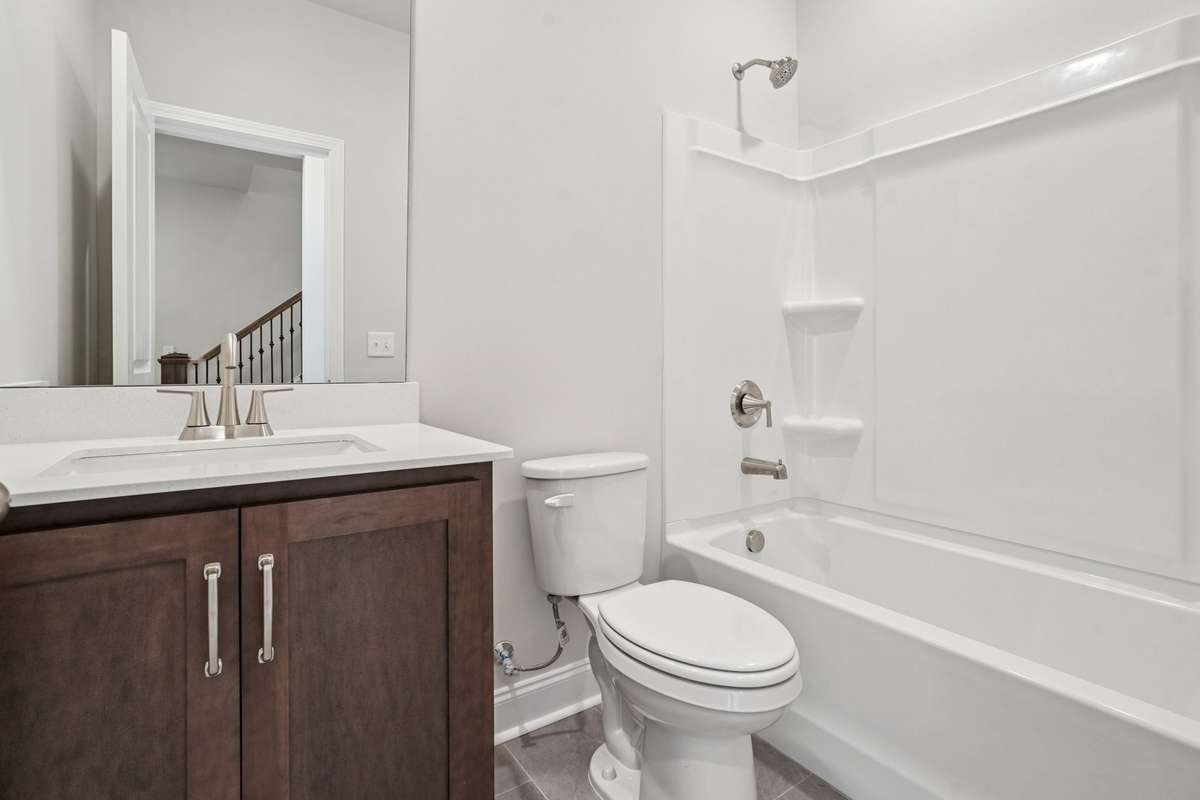 Bath 2, located on the lower level, features tile flooring and quartz countertops for a clean, modern look.