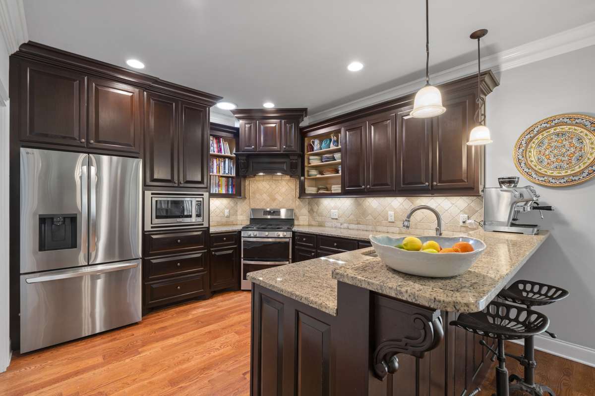 A well-equipped kitchen has bar for dining and there is also a walk-in pantry.