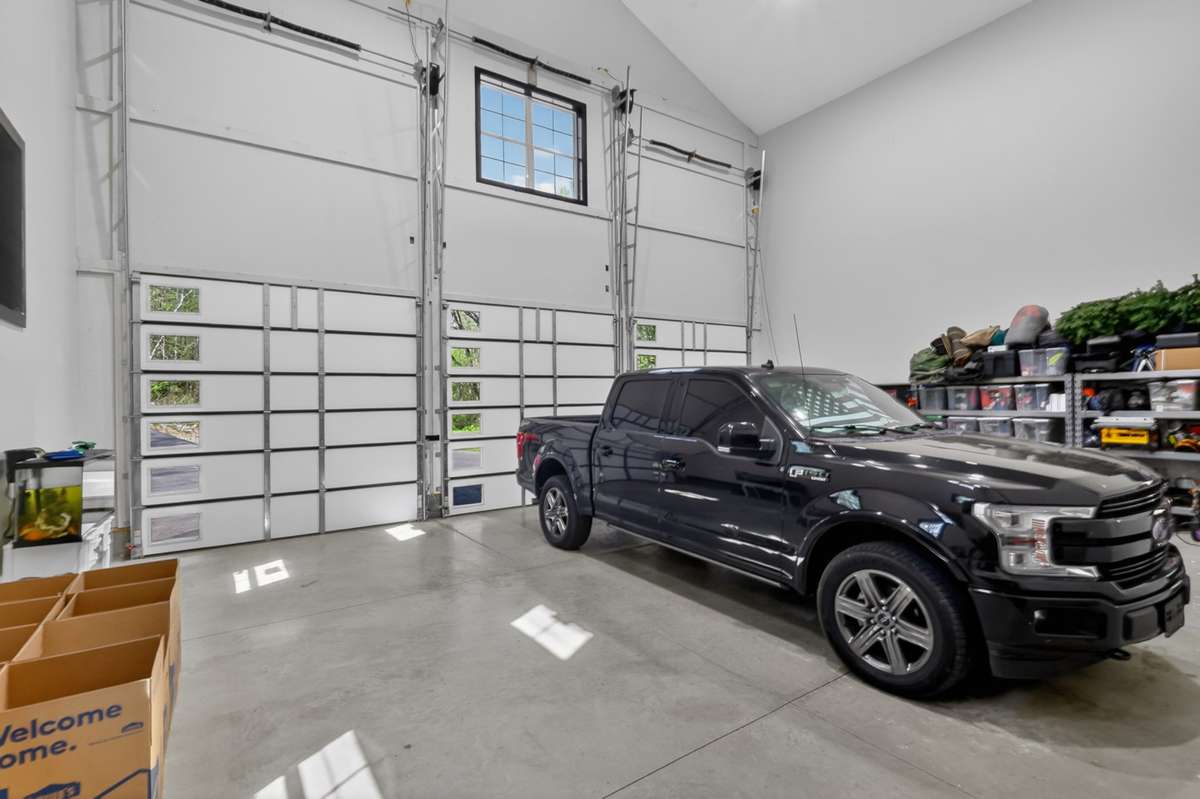 Spacious 3-car garage with soaring 30+ ft ceilings, perfect for car enthusiasts.