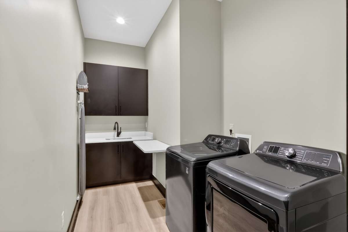 Functional laundry room featuring a sink, built-in cabinetry, and a folding table. Washer and dryer are negotiable.