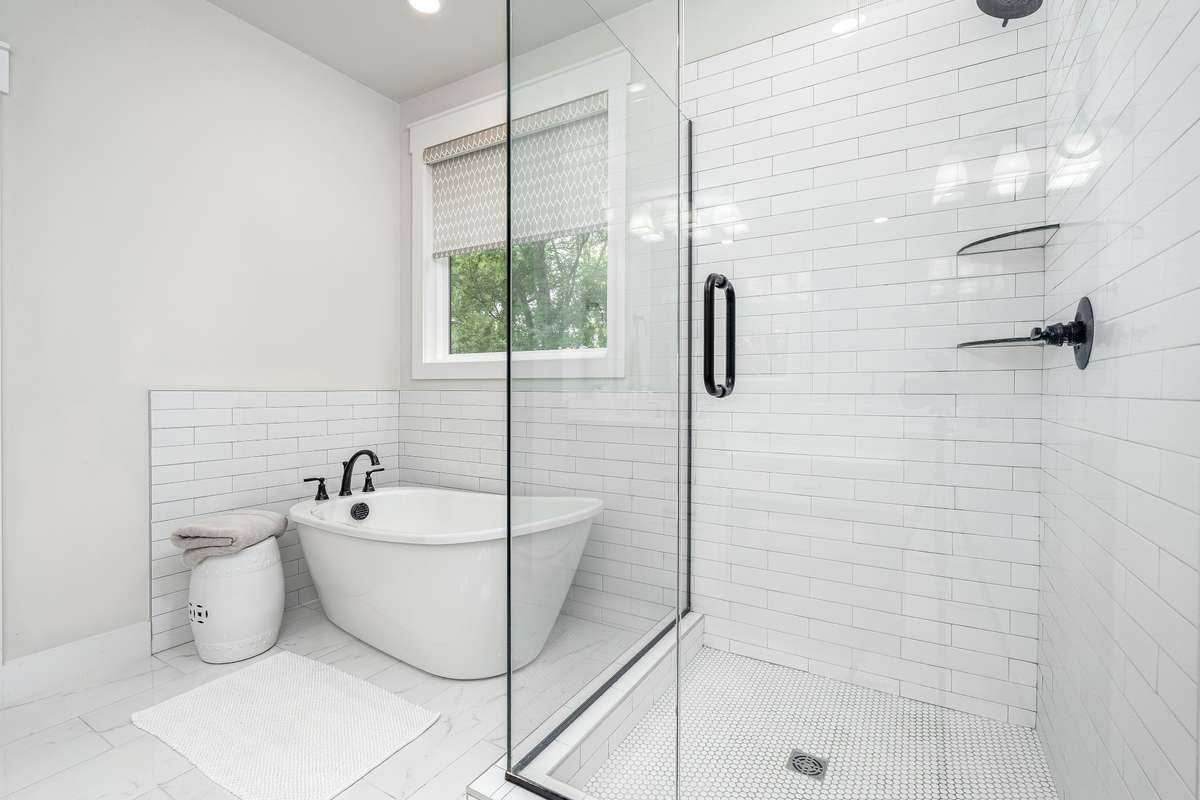 Beautiful soaking tub and glass surround tiled shower