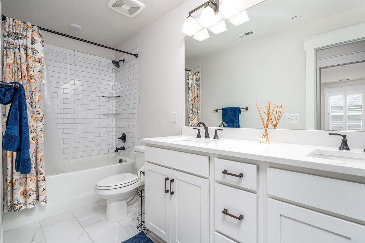 Bathroom located in the upstairs Hallway- Tiled shower/tub combo and double sink