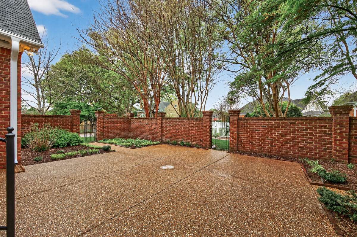 Step into the courtyard before exiting through the gates to your well manicured backyard space.