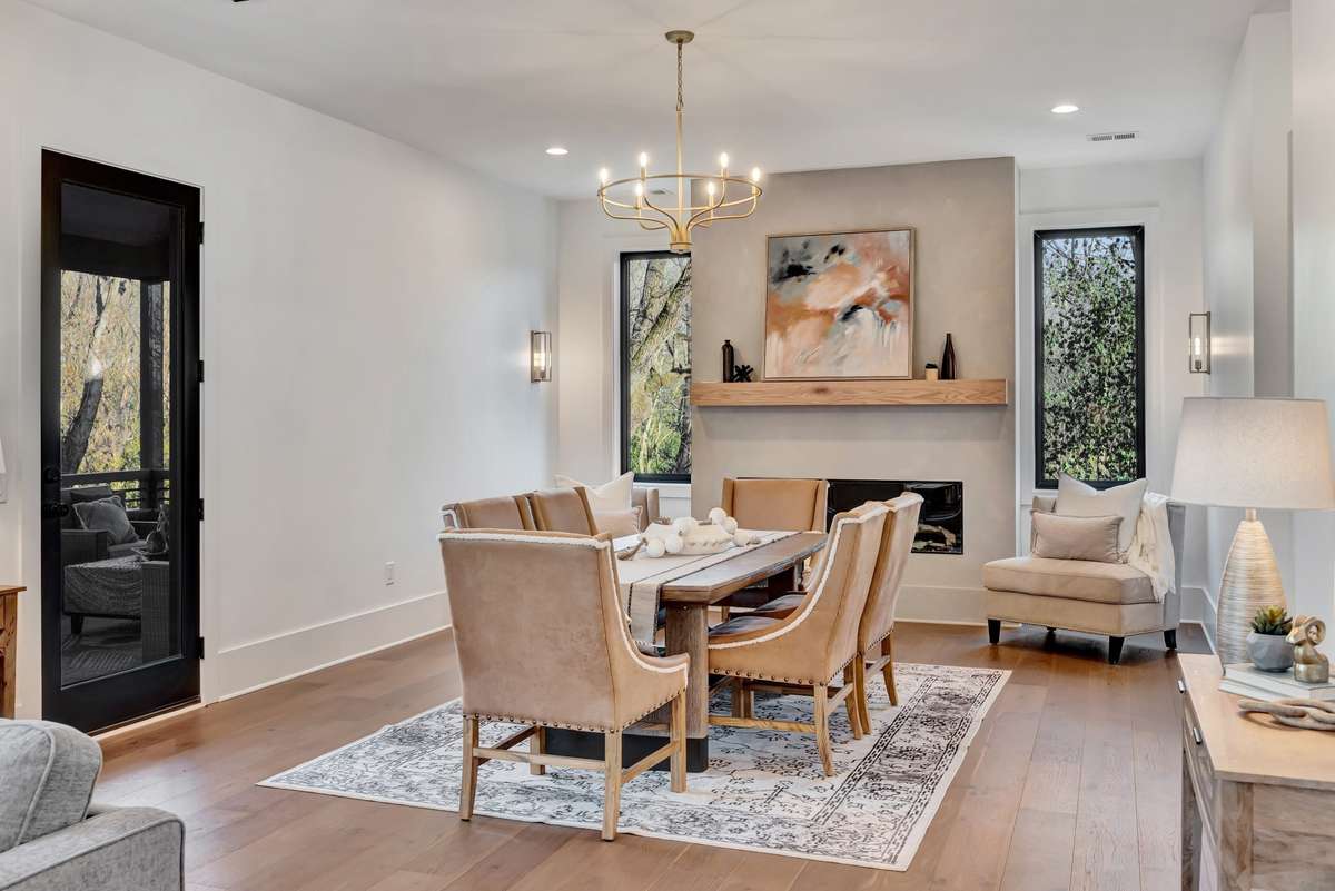 A Sophisticated Dining Area w Fireplace and access to the Covered Porch / Outdoor Entertainment Space