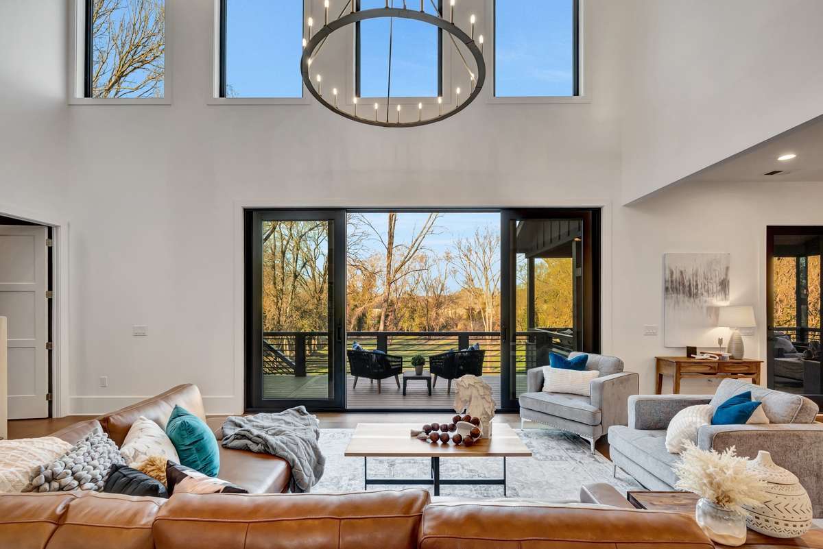 Expansive Great Room w Soaring Ceilings Walls of Glass overlooking the Private Lawn and Harpeth River The Dining Area adjoins to the Right the Primary Bedroom to the Left Kitchen adjoins also capturing the views