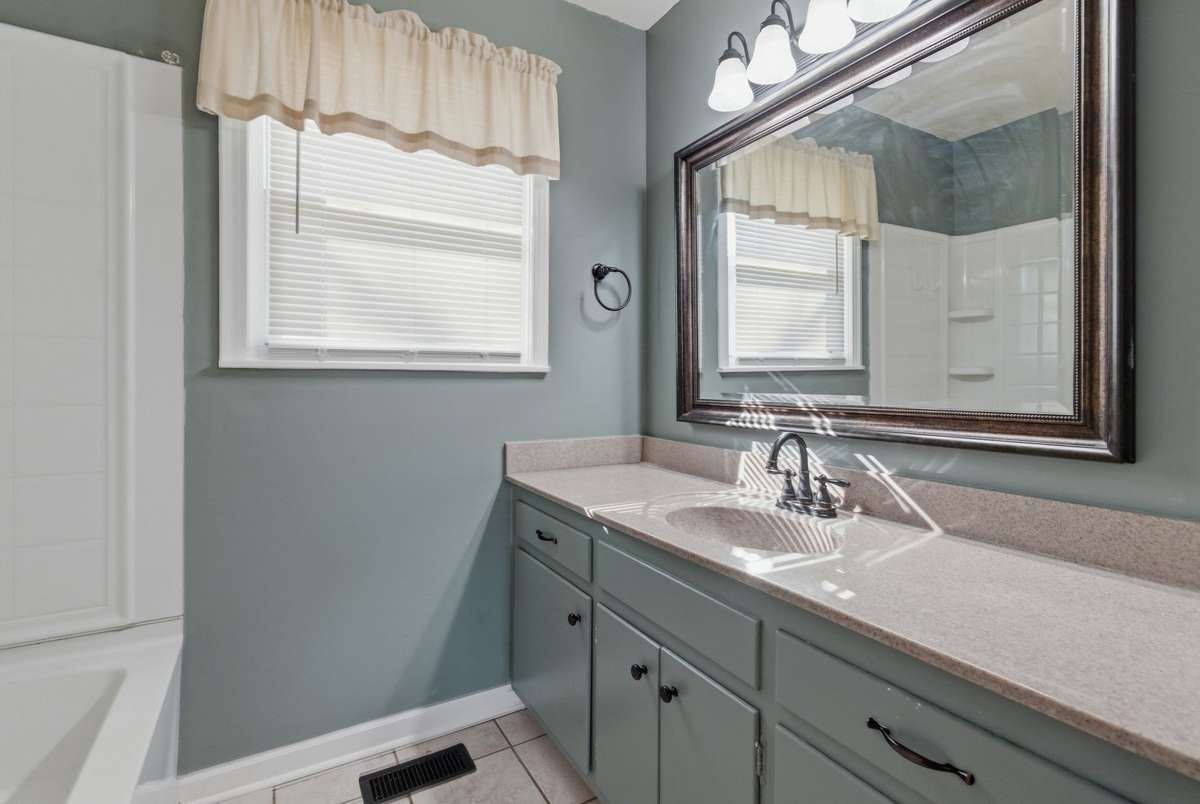 The Bathroom features TILE FLOORING, a LARGE VANITY and COMBO SHOWER & TUB.