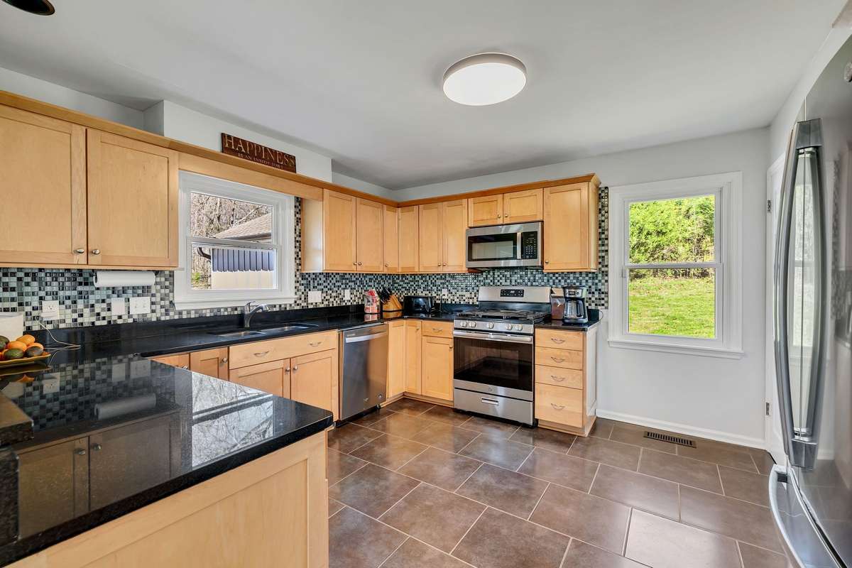 Kitchen with granite counter tops, stainless appliances.  Home has natural gas for one unit, Heat pump for another and a gas range.