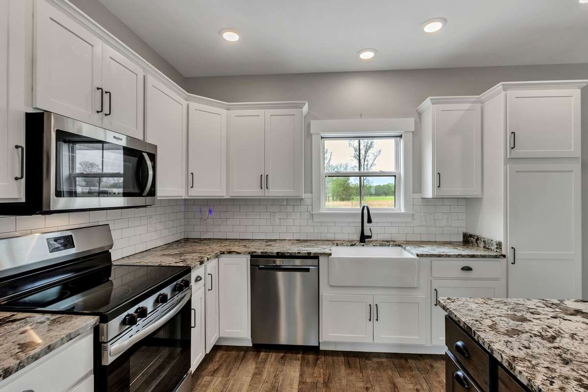 White subway tile backsplash is just another one of the many features this kitchen offers