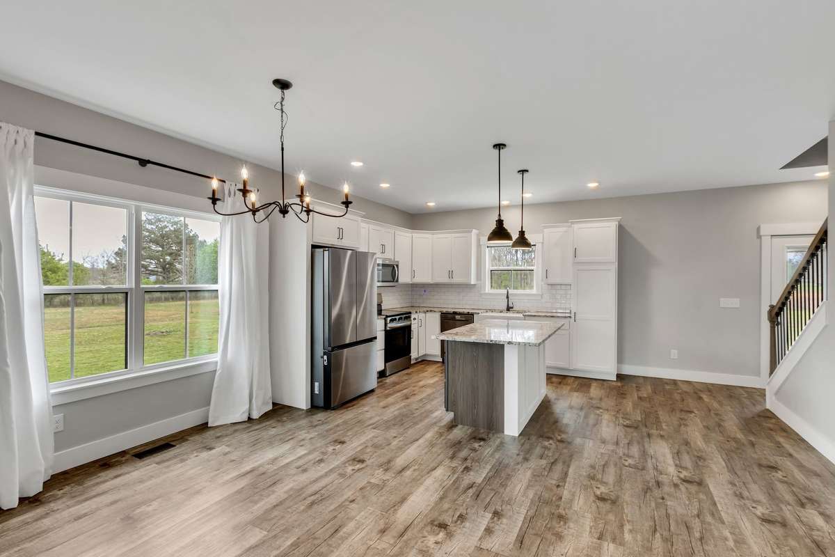 The kitchen featues an island, granite counters, farmhouse sink and new stainless steel refrigerator with dual option ice maker