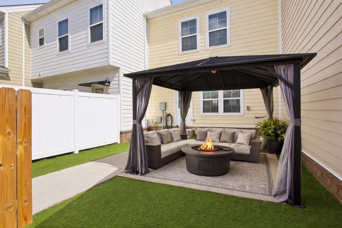 Private courtyard with covered patio and turf for convenience- Digitally staged photo