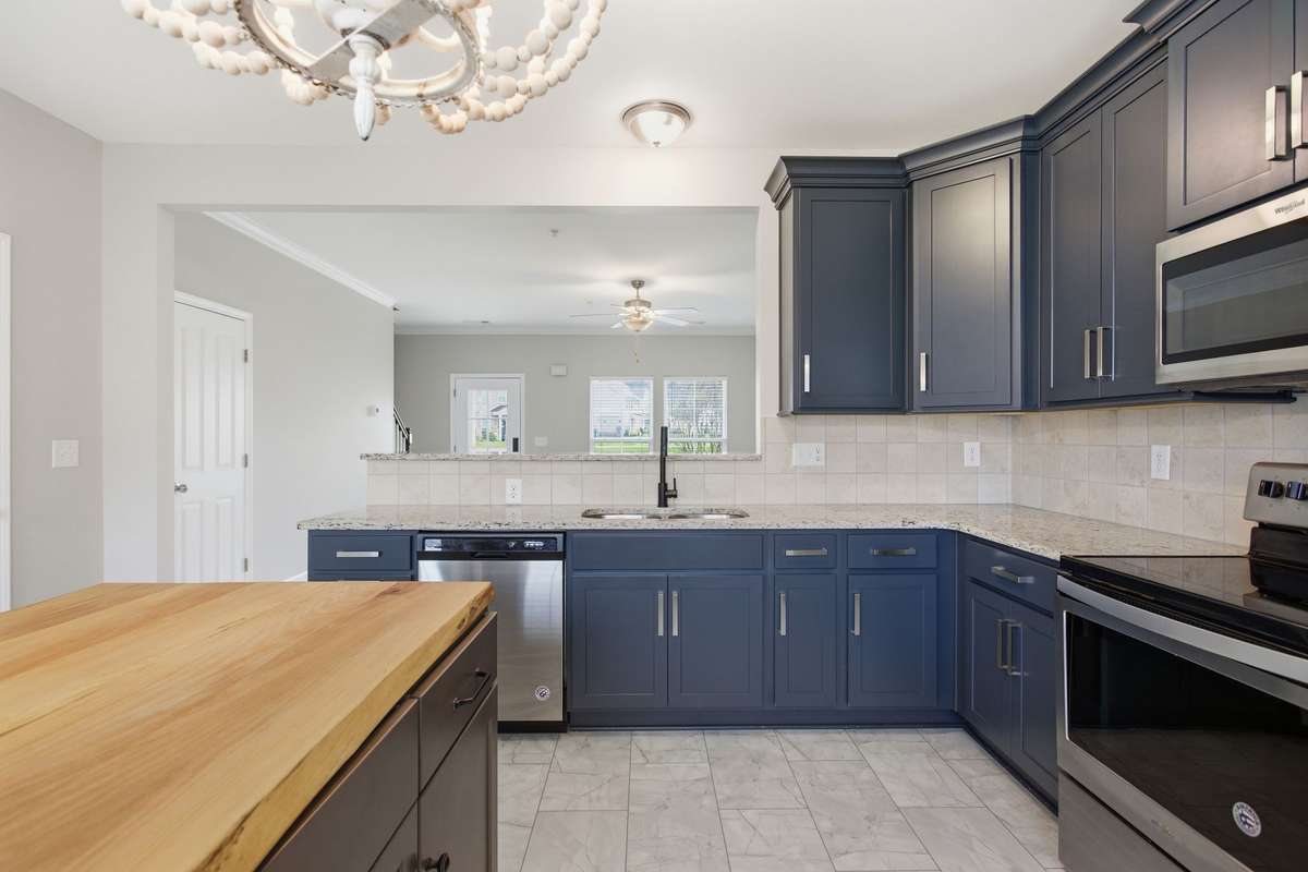 Custom cabinetry with designer selections in Kitchen open into the Living Room.