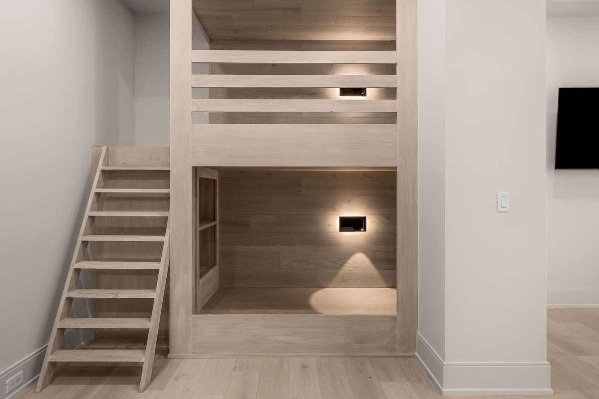 Built-in bunk beds with integrated lighting create a cozy, modern retreat designed for both comfort and style.