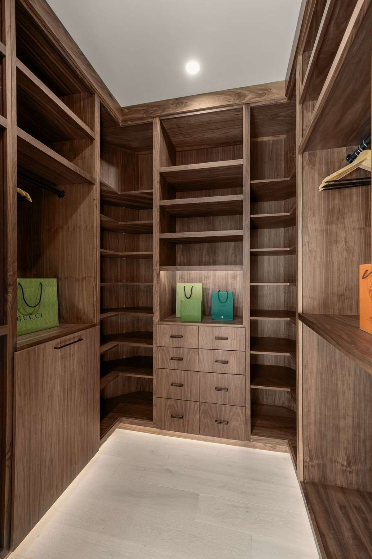His custom walk-in closet wrapped in rich walnut, thoughtfully designed with tailored storage, integrated lighting, and boutique-style display—bringing organization and luxury together in perfect balance.