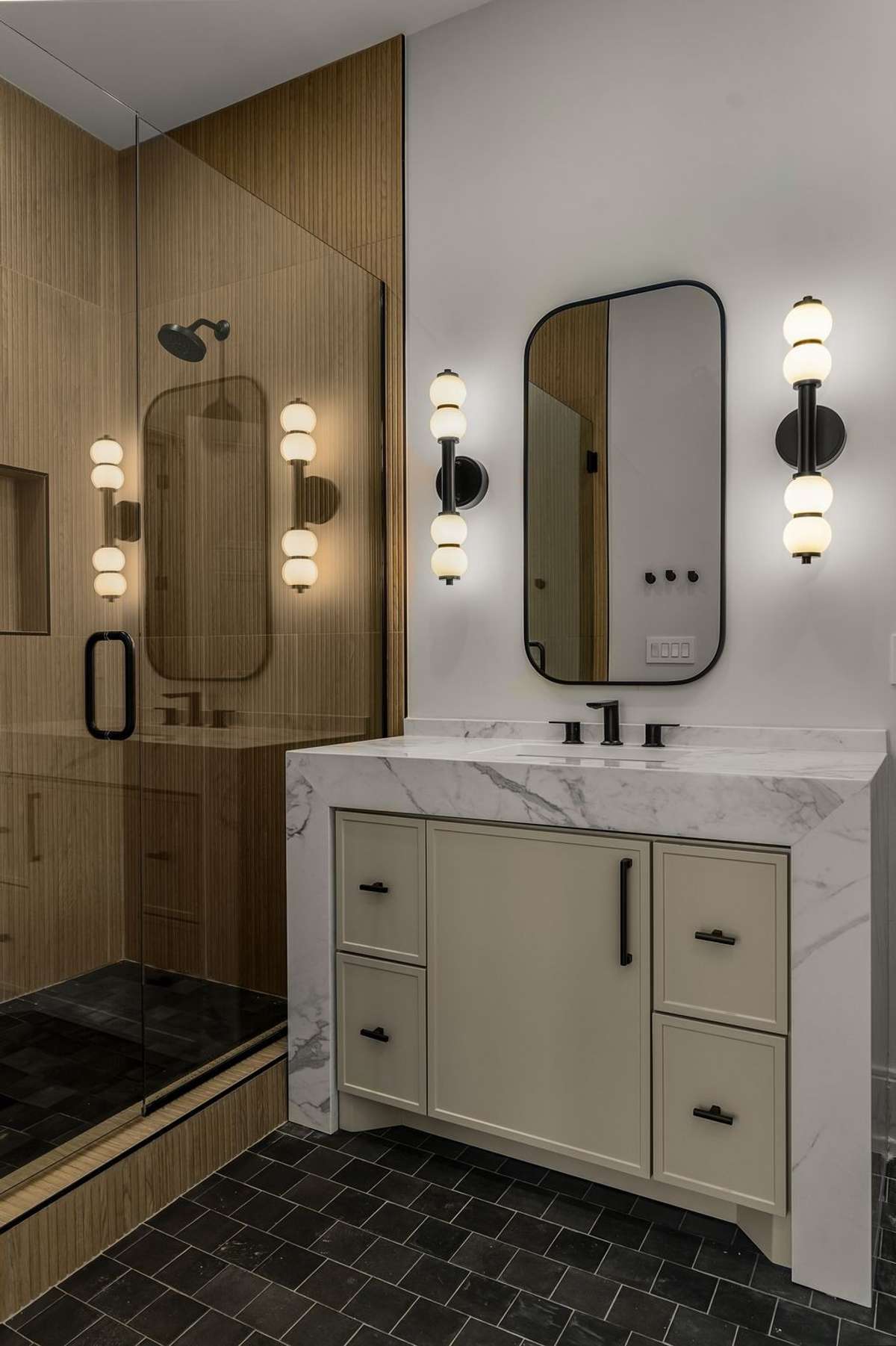 Another elegant bath with designer lighting and glass-enclosed shower.