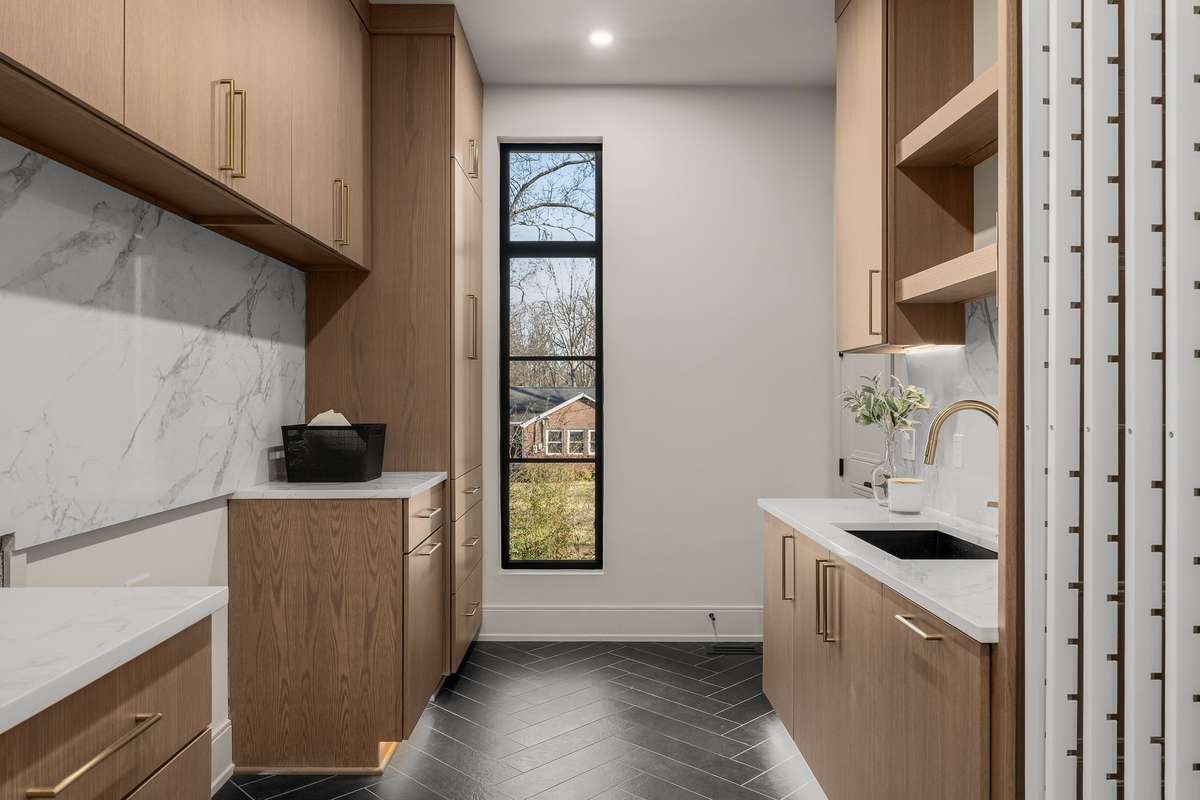 An elevated laundry room featuring abundant storage and built-in sliding drying racks.