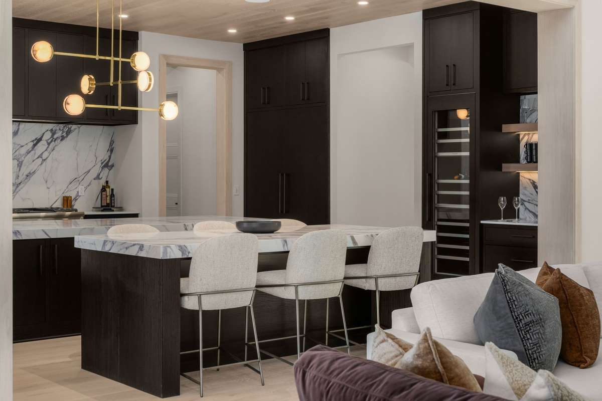 The kitchen makes a statement while remaining highly functional, with a paneled refrigerator and built-in wine column setting the tone.