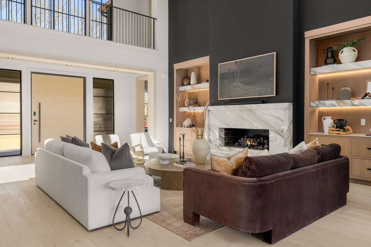 Soaring ceilings, dramatic scale, and a striking marble fireplace create a living space that feels both grand and inviting.