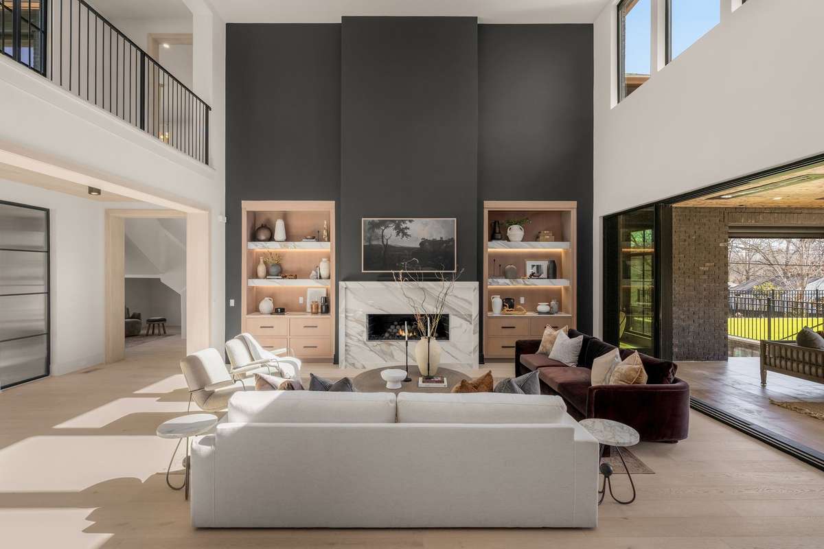 Walls of glass frame the outdoors, enhancing the home’s open flow and vertical scale.