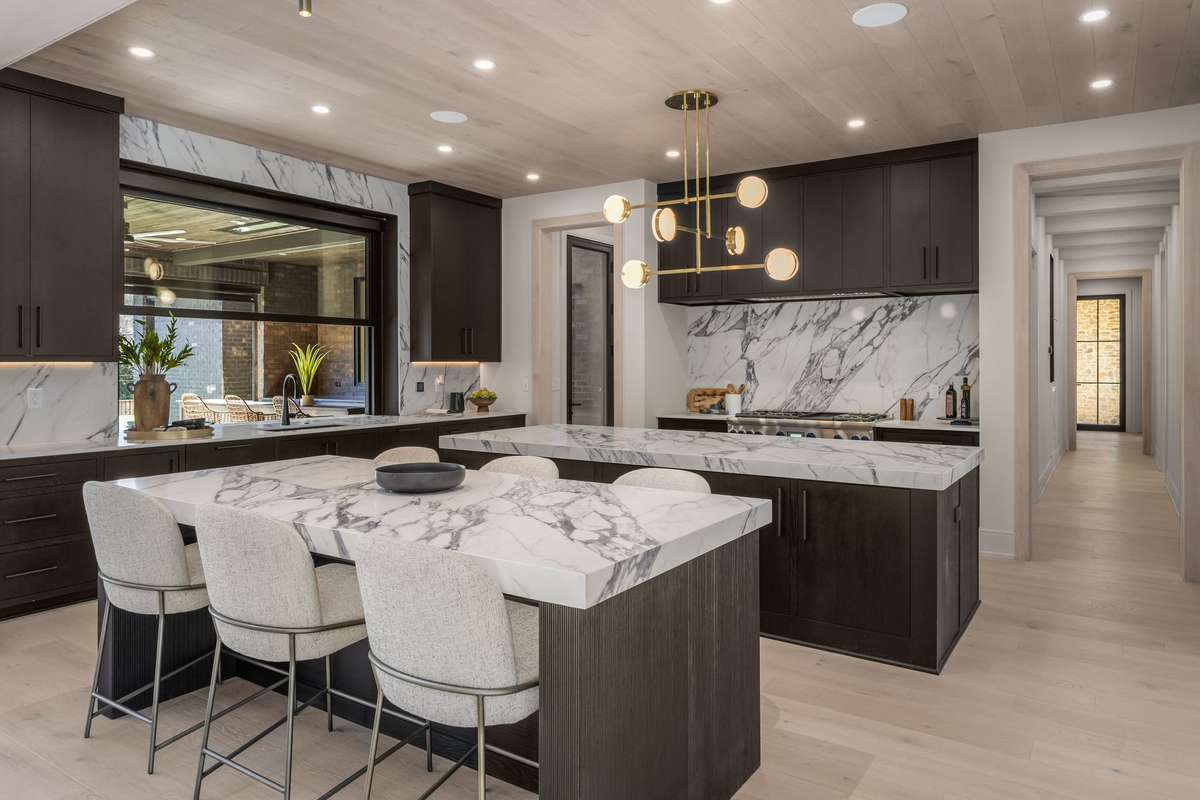 Two oversized marble islands create space to prep, serve, and gather—making the kitchen the natural center of daily life.
