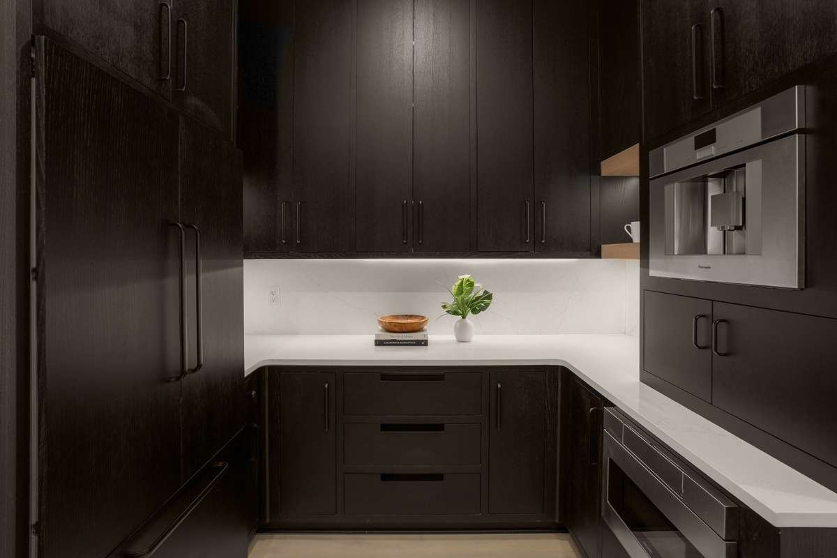 Designed with entertaining in mind, the prep kitchen offers a second refrigerator, microwave, built-in espresso machine, and abundant storage—allowing the main kitchen to remain polished and guest-ready.