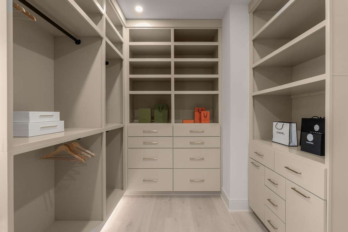 A boutique-inspired dressing room, her closet features custom built-ins, soft ambient lighting, and tailored storage for effortless organization.