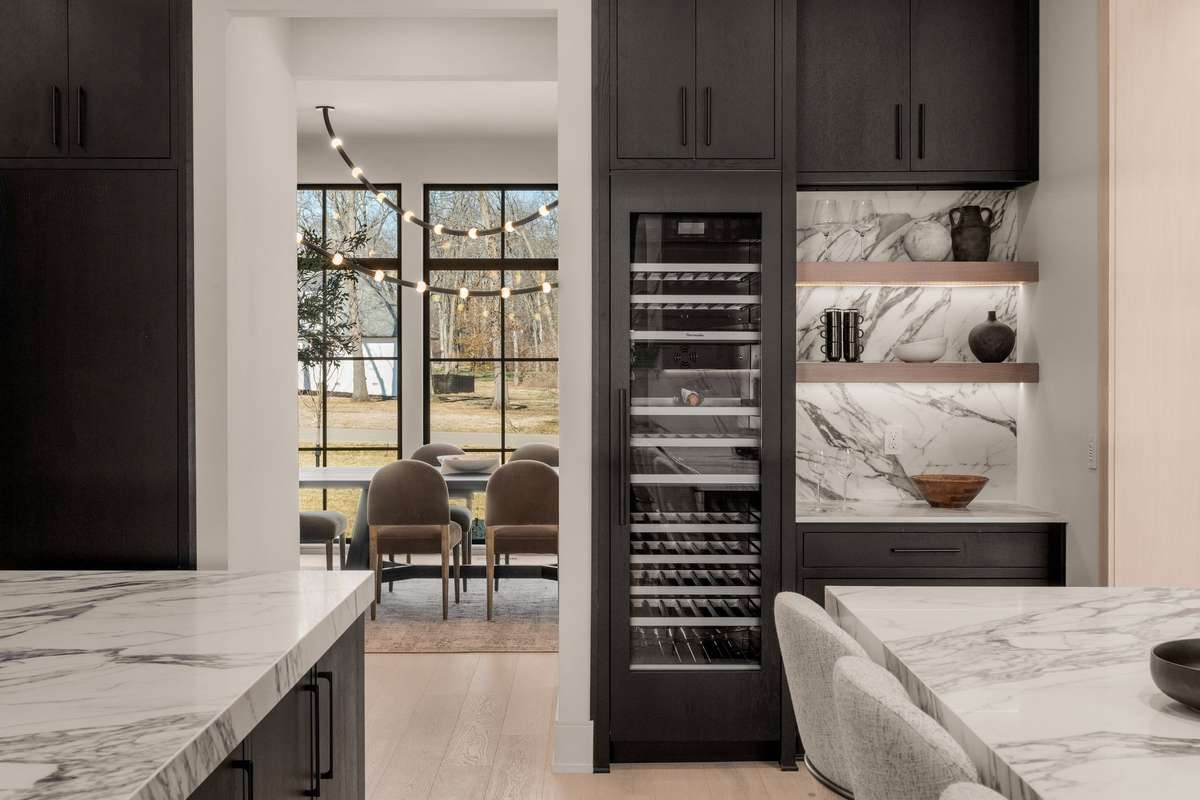 A temperature-controlled wine column and tailored serving station create a sophisticated transition to the dining room.
