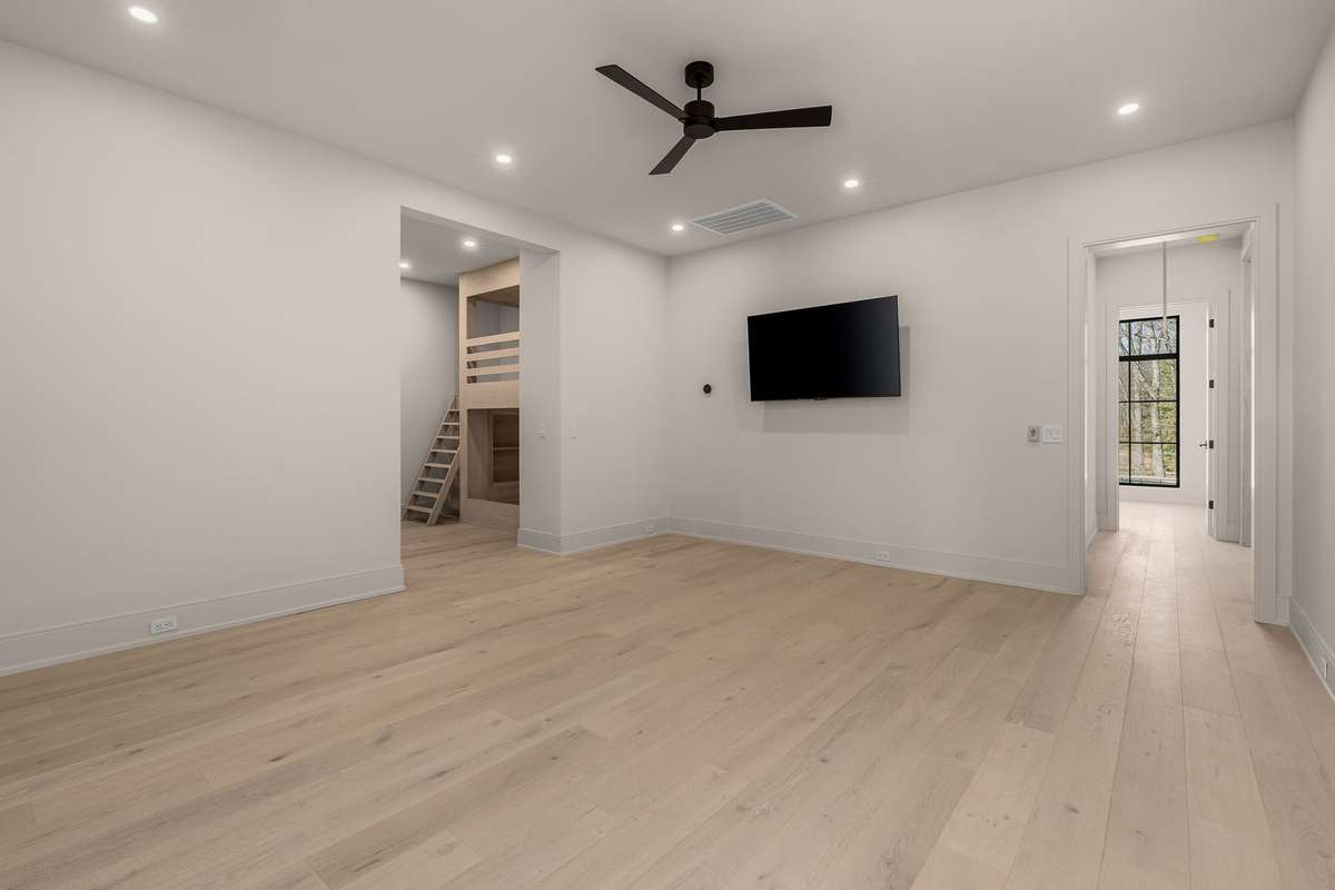Upstairs a spacious bonus room with clean lines, wide-plank floors, and endless potential—from media lounge to playroom or private retreat.