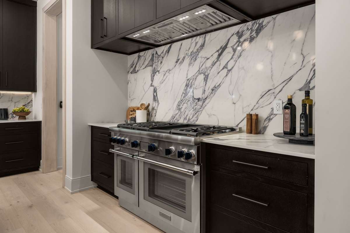 A professional-grade Thermador gas range and full marble backsplash bring both performance and statement design to everyday cooking.
