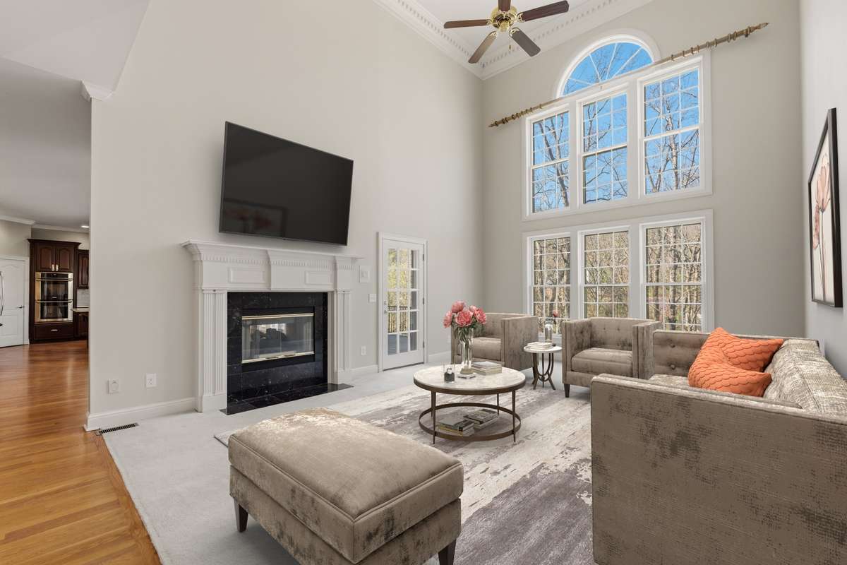 Great Room beside kitchen with a double-sided fireplace - Virtually Staged