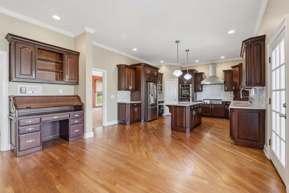 Renovated Eat in kitchen with fireplace, hardwood floors, spacious pantry, warming ovens and compactor.