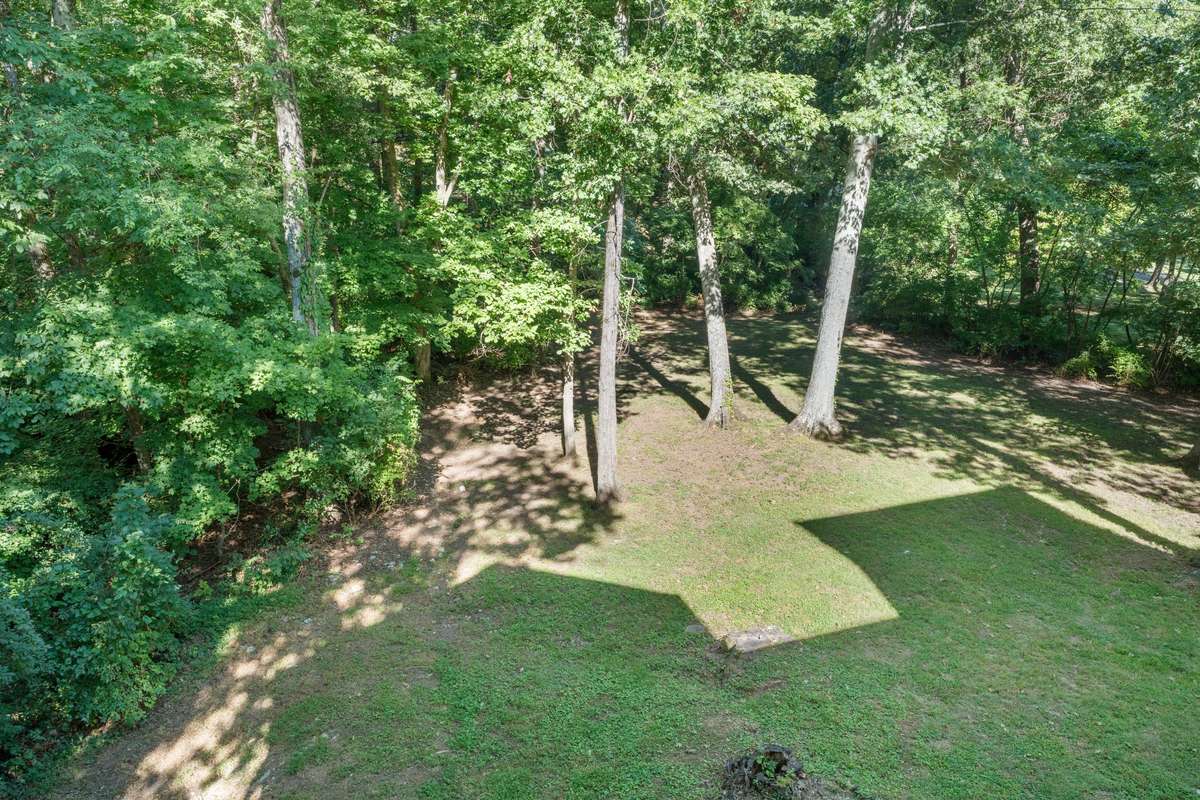 Spacious and private lot surrounded by mature trees for privacy. The lot offers a gentle slope with ample flat space beyond.