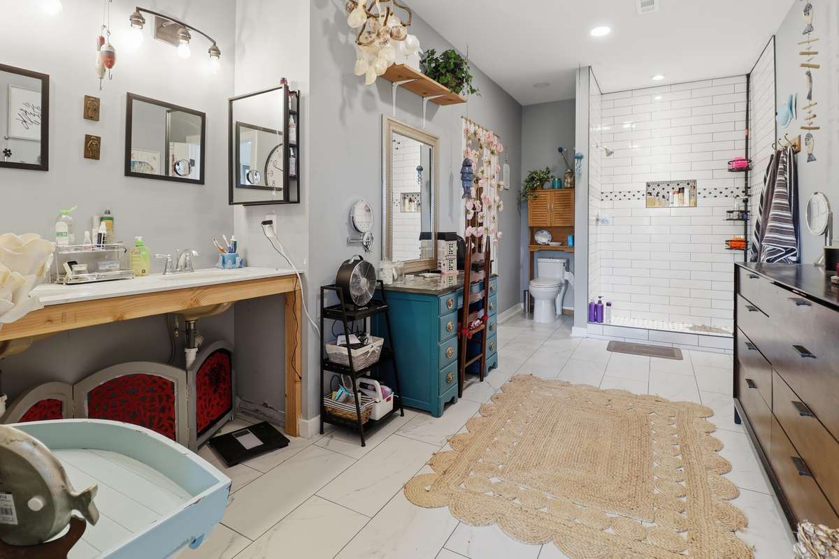 Extraordinary master bath large enough for dresser and vanity with double sink and tile shower.