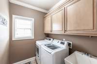 Located on the main level, the utility room offers ample storage space and a soaking sink, combining function and convenience for everyday living.