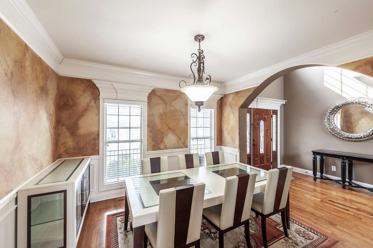 The formal dining room features exquisite millwork and refined arched entryways, adding architectural charm and character.