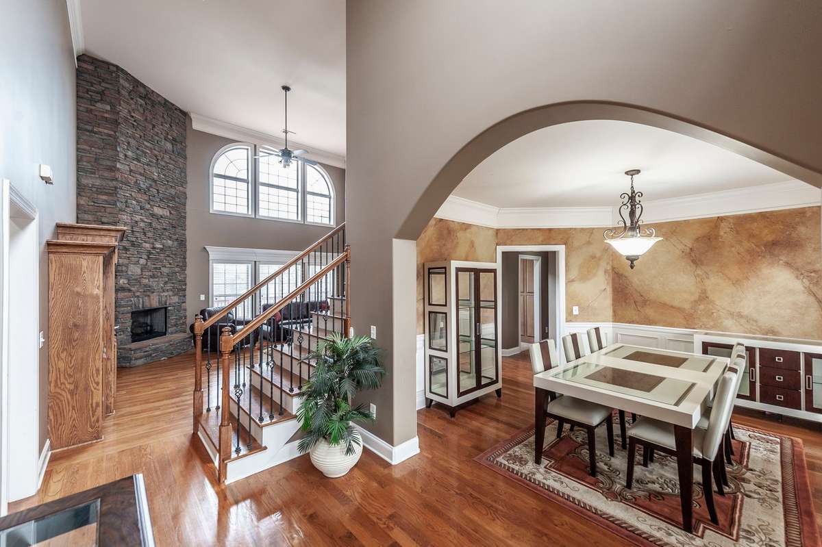 From the moment you enter, you are welcomed by a dramatic two-story great room anchored by a gas fireplace, creating an impressive yet inviting atmosphere.