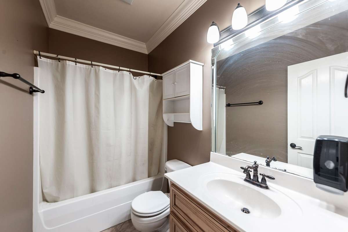 The first-floor guest room is complemented by a full bath located just outside the doorway for added convenience.