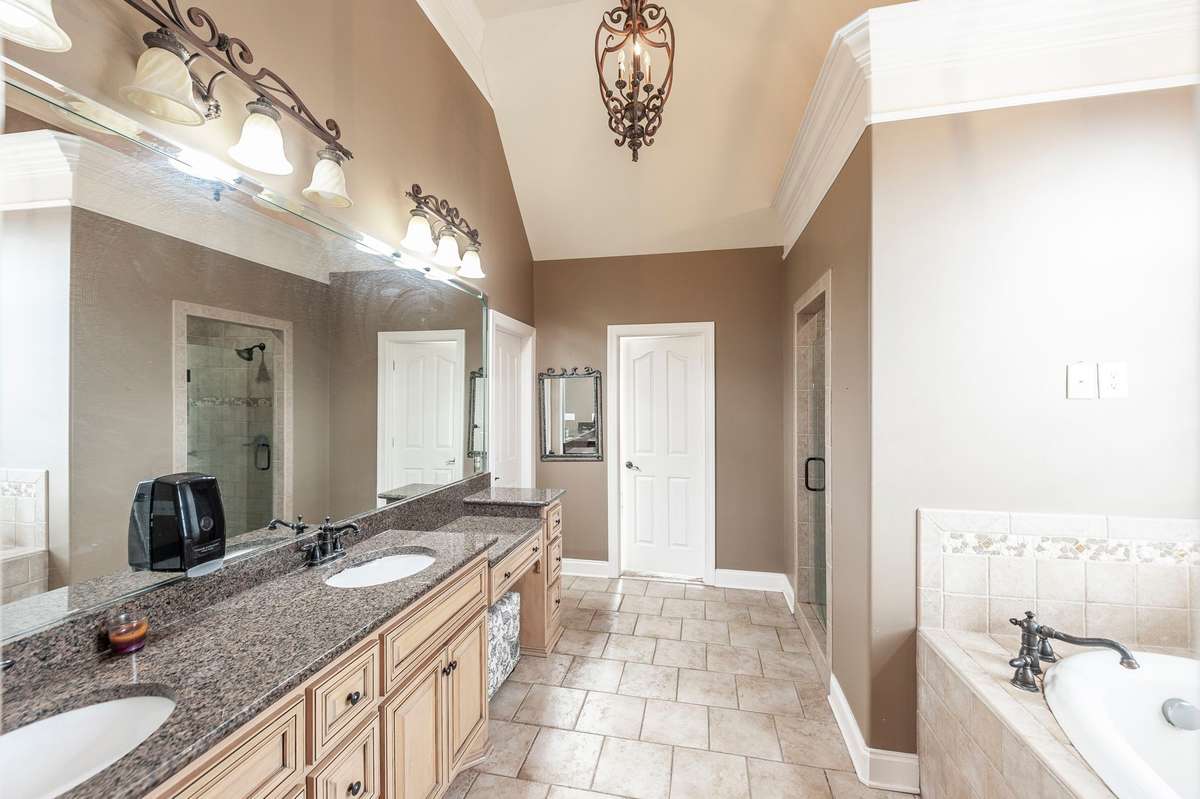 The primary en-suite bath is thoughtfully designed with dual vanities, a soaking tub, a separate walk-in shower, and an expansive walk-in closet.