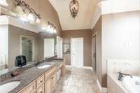 The primary en-suite bath is thoughtfully designed with dual vanities, a soaking tub, a separate walk-in shower, and an expansive walk-in closet.