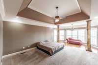 The first-floor primary suite serves as a tranquil retreat, highlighted by a tray ceiling and a dedicated sitting area for relaxation.