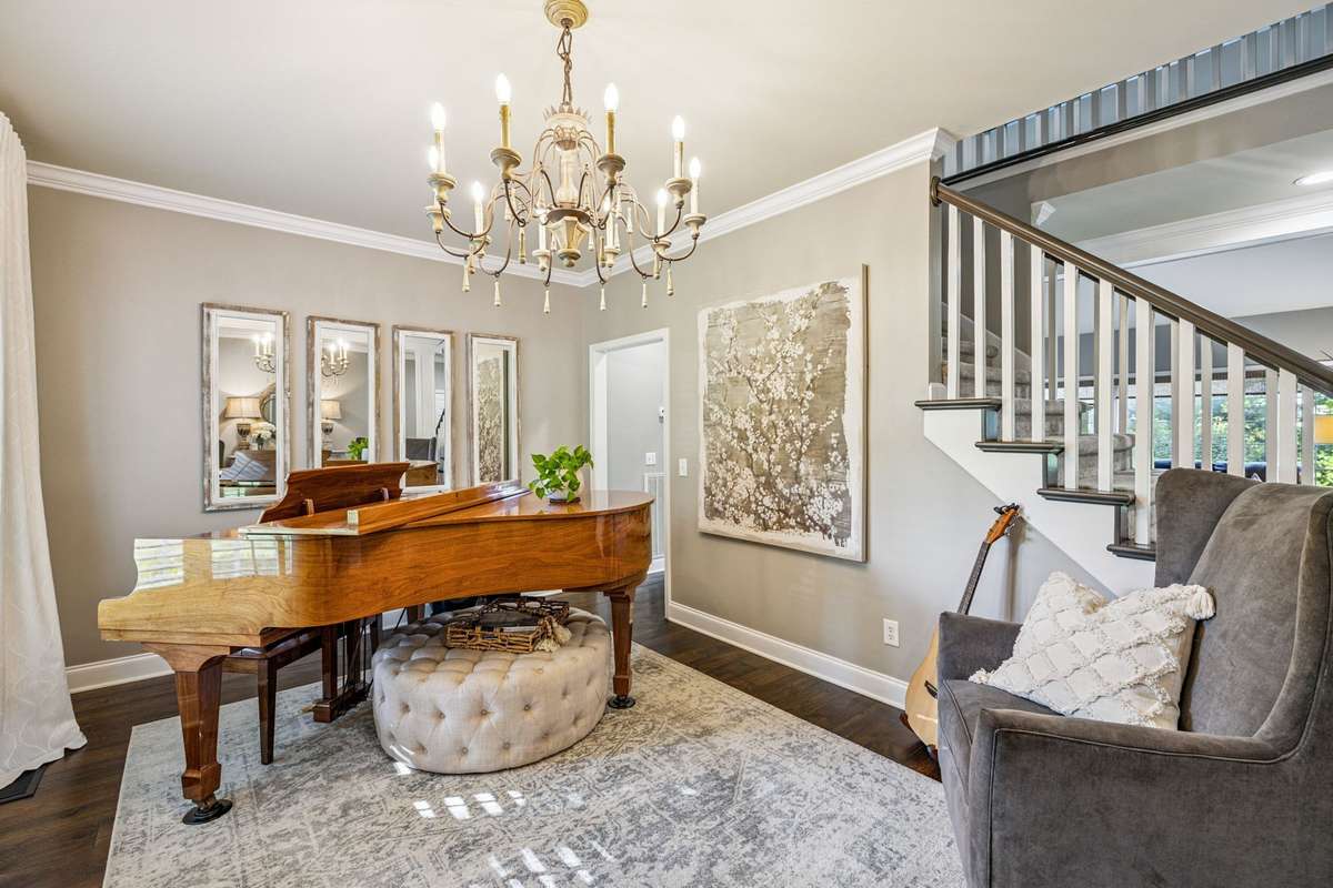 The Formal Dining Room has a beautiful new light fixture, plantation Shutters, hardwood floors and crown molding
