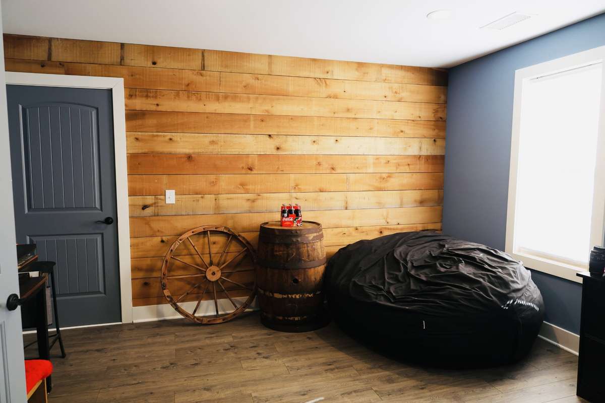 Upstairs bonus room with accent wall and walk in storage.