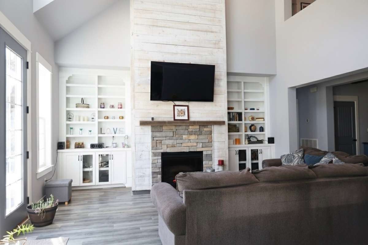 Great room with built in book shelves and electric fireplace.