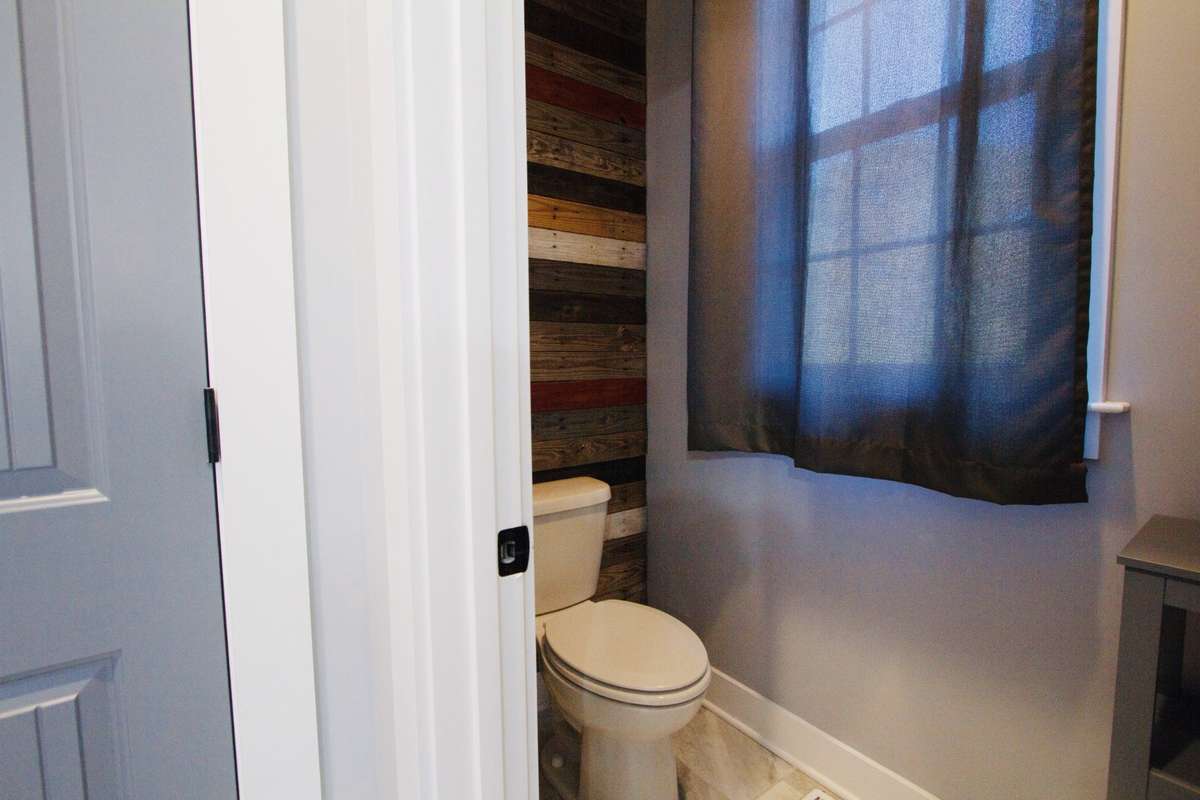 Water closet in primary bath with accent wall.
