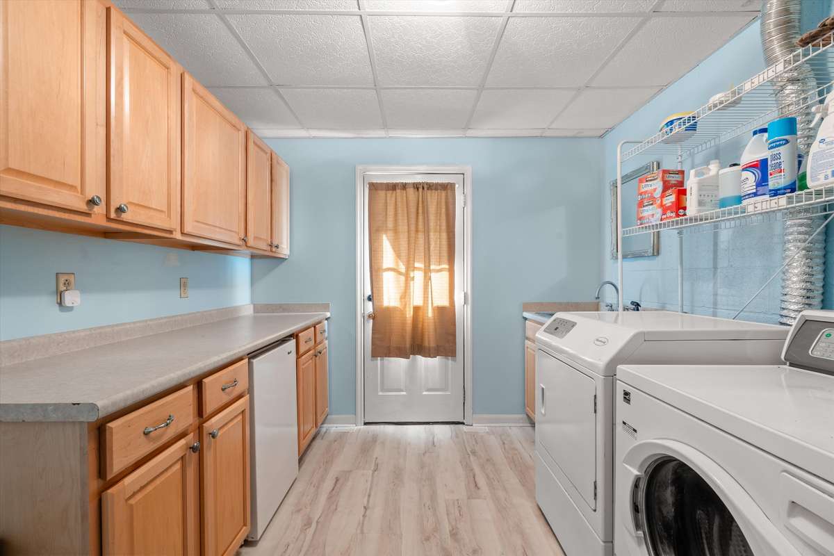Grand utility room: storage, folding space, a mini-frig, utility sink, and high-end commercial Huebsch washer and dryer included