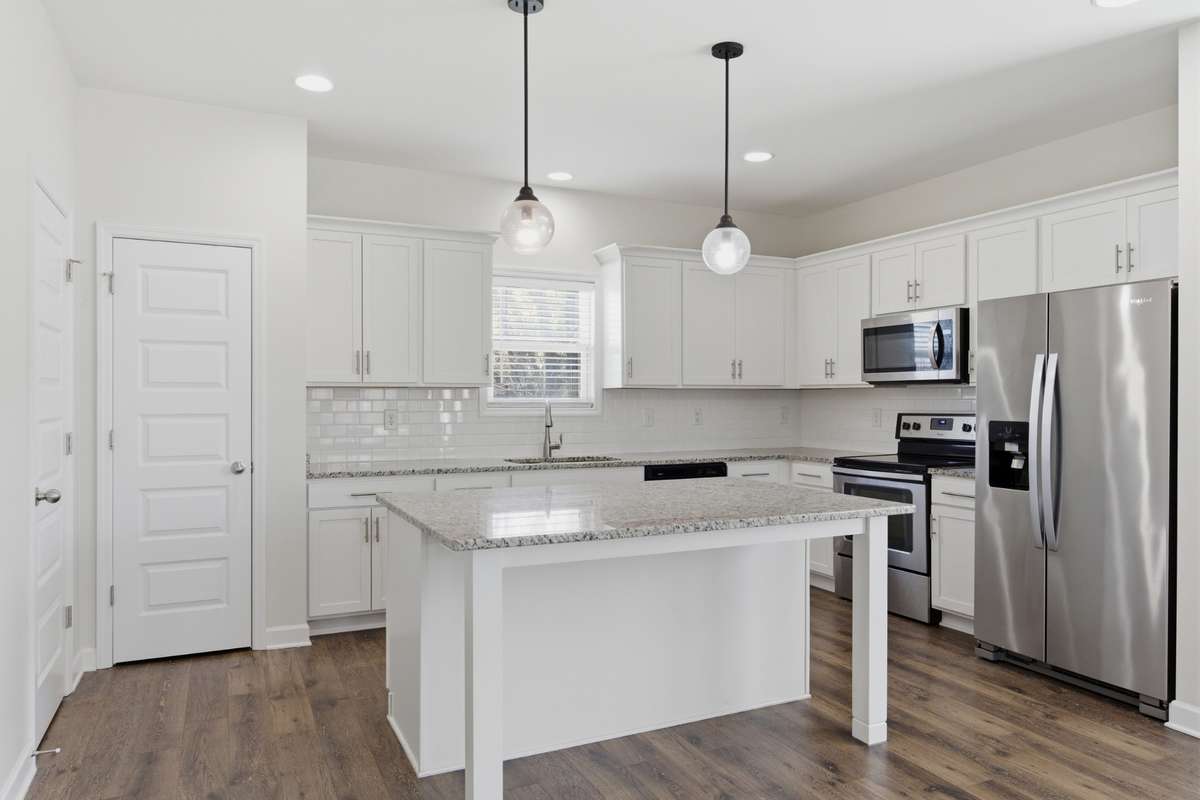 Open kitchen featuring a large island, stainless steel appliances, and ample cabinet storage.