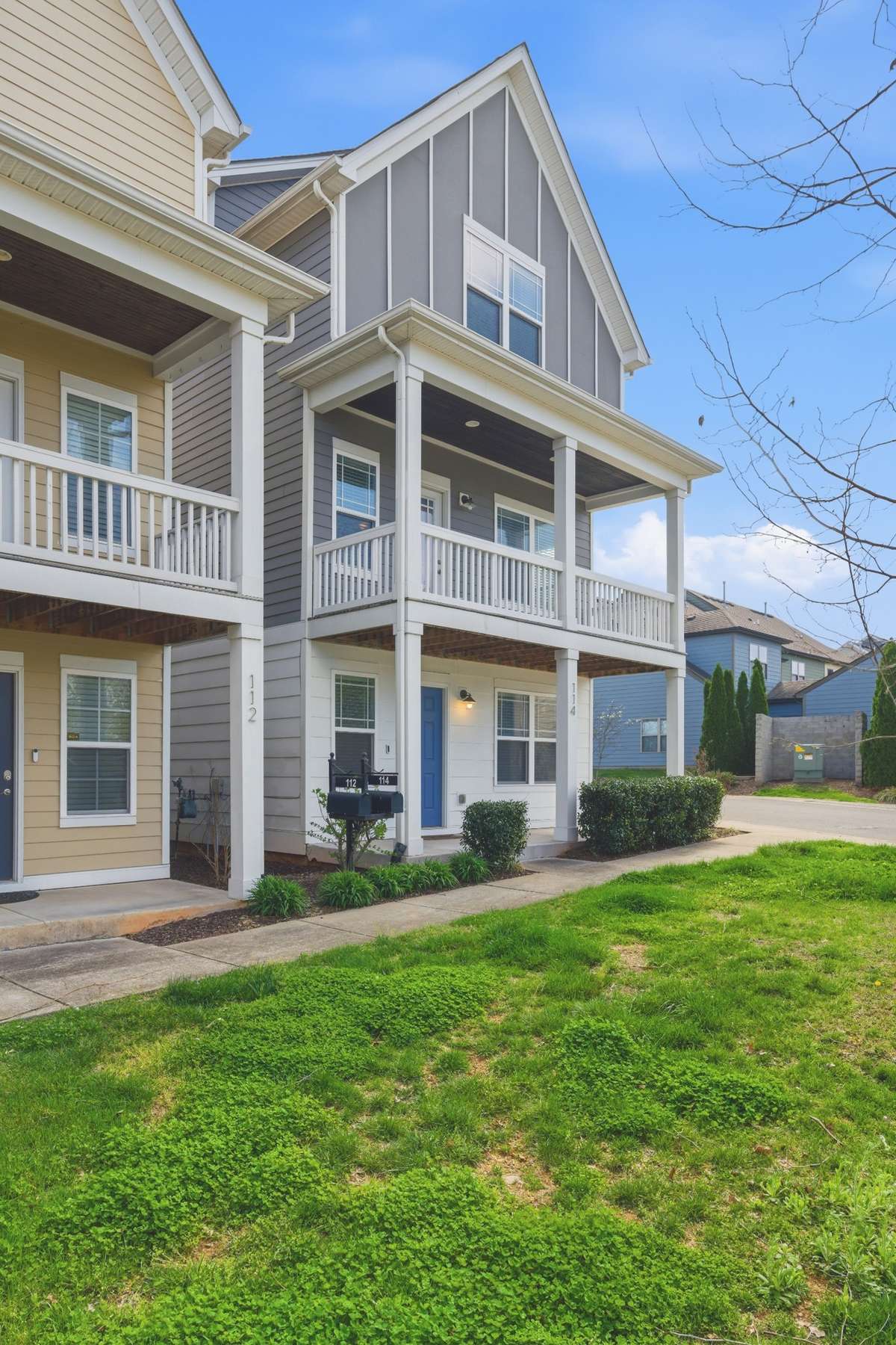 Welcoming covered front porch complemented by an upper-level balcony for added outdoor space.